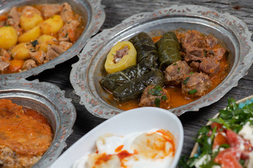 Eid Mubarak Traditional Ramadan Iftar dinner. Assorted tasty food in authentic rustic dishes on wooden table background.