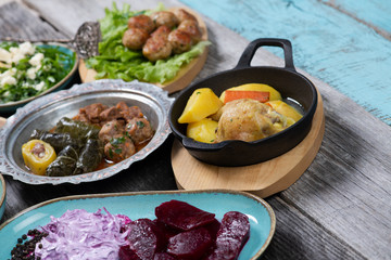 Eid Mubarak Traditional Ramadan Iftar dinner. Assorted tasty food in authentic rustic dishes on wooden table background.