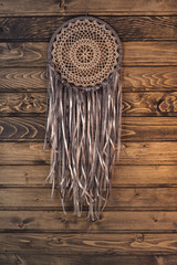 Dream catcher on the background of wall and wooden logs. 