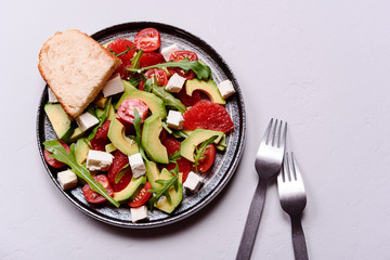 Vegetarian salad with avocado, grapefruit, tomato, feta cheese and arugula. Healthy nutrition. Selective focus