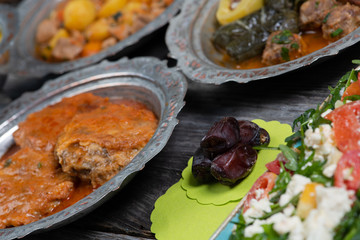Eid Mubarak Traditional Ramadan Iftar dinner. Assorted tasty food in authentic rustic dishes on wooden table background.