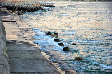 Concrete city breakwater and waves at the black sea. Varna, Bulgaria