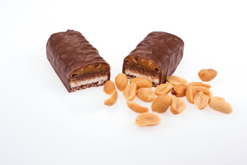 Chocolate peanut butter energy bar with peanuts in the foreground