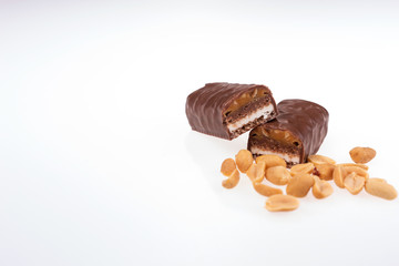 Chocolate peanut butter energy bar with peanuts in the foreground