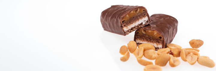 Chocolate peanut butter energy bar with peanuts in the foreground