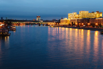 Obraz premium View of the night city from the bridge. Lanterns illuminate the promenade