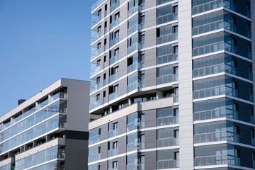 Exterior of new apartment buildings on a blue cloudy sky background. No people. Real estate business concept.