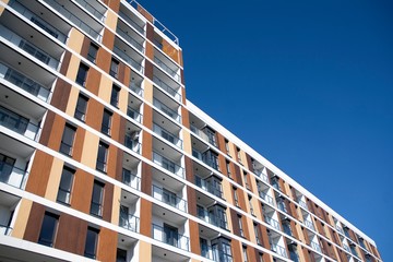 Exterior of new apartment buildings on a blue cloudy sky background. No people. Real estate business concept.