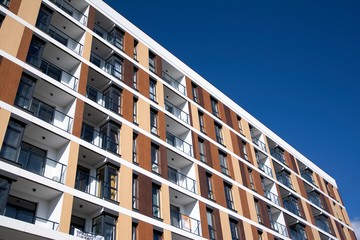 Exterior of new apartment buildings on a blue cloudy sky background. No people. Real estate business concept.