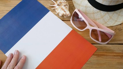 covid - 19, coronavirus concept, sun hat, sunglasses, sea shell, France flag and medical mask on wooden background, flat lay, borders are closed, problems in the tourism business due to coronavirus  - Powered by Adobe