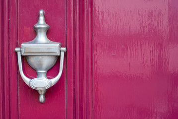 Clean silver knocker on pink background.