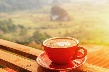 Cup of coffee on wooden table background.
