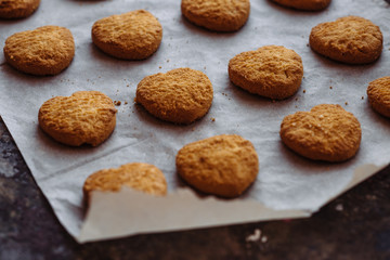 Freshly baked heart-shaped cookies on parchment paper