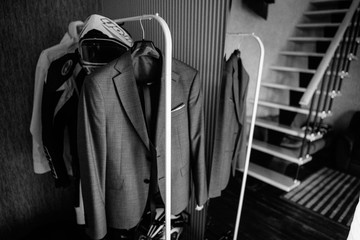 Fototapeta na wymiar Men's jackets on hangers in the men's store. Row of men's suit jackets hanging in closet.