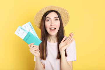 Beautiful young smiling girl holds tickets for travel. Rest, travel, tour.