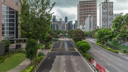 Fototapeta premium Traffic with cars on a street and urban scene in the central district of Singapore timelapse
