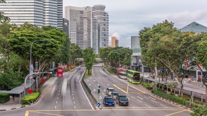 Obraz premium Traffic with cars on a street and urban scene in the central district of Singapore timelapse