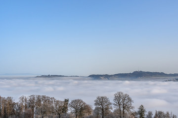 Verschneiter Wanderweg über dem Nebelmeer