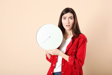 Girl holds a mechanical clock on a colored background