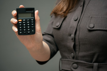 Calculator with zero on the display in business lady hands close up.