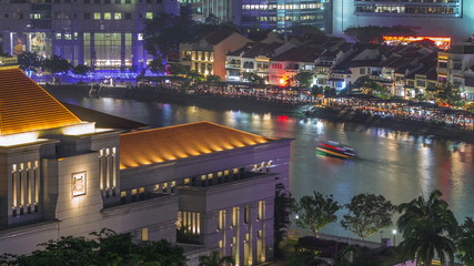 Parliament House in downtown Singapore aerial night timelapse and boat quay in the background.