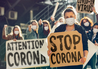 Young people protesting of stop coronavirus pandemic on the street. Caucasian women have meeting...
