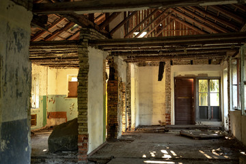 Old abandoned soviet military barrack building in ruins. House interior with broken floor and walls.