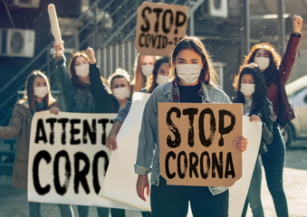 Young people protesting of stop coronavirus pandemic on the street. Caucasian women have meeting...