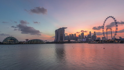 Downtown skyline of Singapore as viewed from across the water from The Garden East day to night timelapse. Singapore.