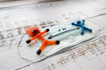 Social distancing for coronavirus (COVID-19) toy man on medical mask