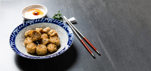 (Hoi Jo or Hai Choe) Deep Fried Crab Meat Rolls. Chinese Traditional cuisine concept. Dumplings Dim Sum in bamboo steamer with text copy space. Asian food background