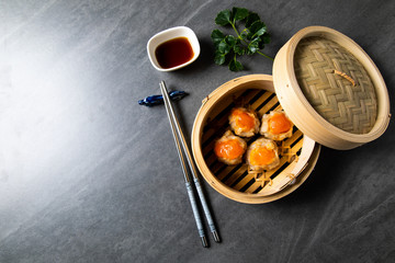 Egg yolk on a pork. Chinese Traditional cuisine concept. Dumplings Dim Sum in bamboo steamer with text copy space. Asian food background