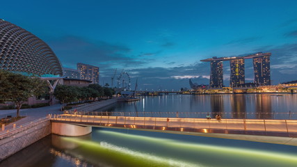 Skyline in Marina Bay with Esplanade Theaters on the Bay and Esplanade footbridge night to day timelapse in Singapore.