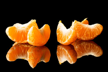 fresh tangerine on a black background with a beautiful reflection