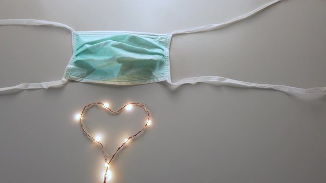 Mascherina chirurgica con simbolo del cuore. Coronavirus, virus definitivamente debellato.