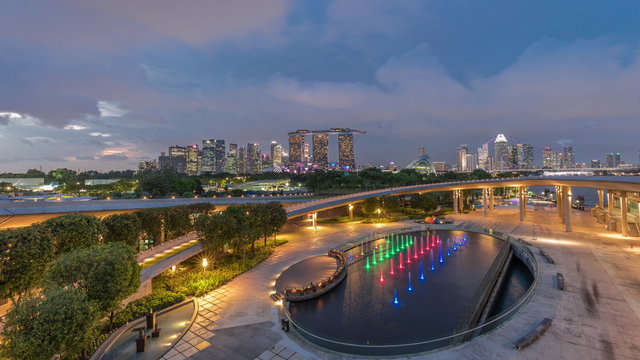 Aerial view after sunset with Singapore city skyline view from Marina barrage garden day to night timelapse.