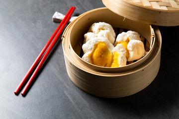 肉まん. steamed Creamy Custard Bun. Chinese Traditional cuisine concept. Dumplings Dim Sum in bamboo steamer with text copy space. Asian food background