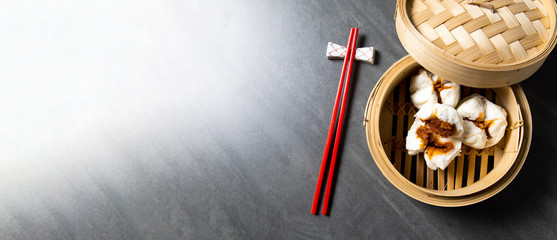 肉まん. steamed pork bun. Chinese Traditional cuisine concept. Dumplings Dim Sum in bamboo steamer with text copy space. Asian food background