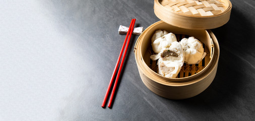 肉まん. steamed pork bun. Chinese Traditional cuisine concept. Dumplings Dim Sum in bamboo steamer with text copy space. Asian food background