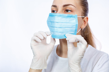 woman health worker demonstrates how to wear a protective medical surgical mask against the virus. Isolated on white background
