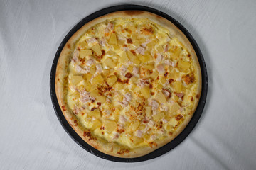 Italian pizza on gray plates on a white plate with spices and seasonings vegetables and meat.