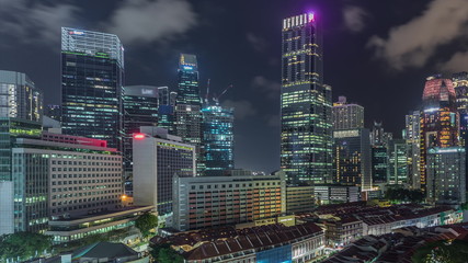 Aerial view of Chinatown with red roofs and Central Business District skyscrapers night timelapse, Singapore