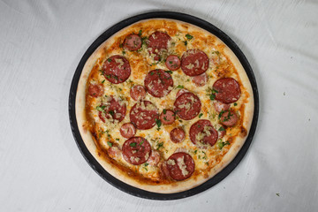 Italian pizza on gray plates on a white plate with spices and seasonings vegetables and meat.