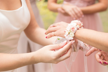 Novia coloca pulsera de flores a dama de honor