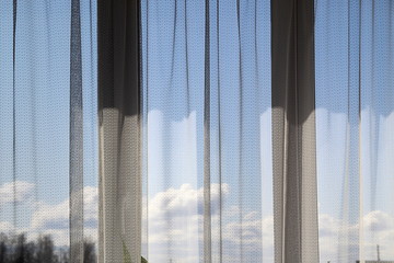 Fototapeta na wymiar Closed tulle window with shadow and sunbeams