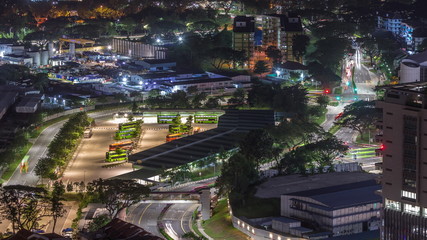Aerial view to busy bus terminal in Singapore night timelapse.