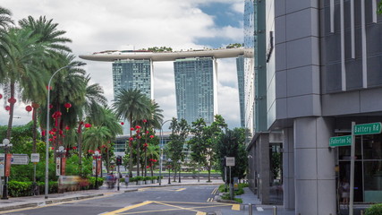 Battery Road avenue with traffic and surrounded by green trees in downtown timelapse hyperlapse, Singapore