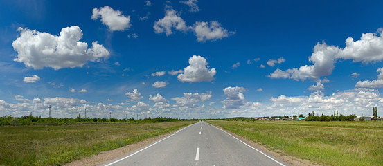 Fototapeta premium a road that goes into the horizon into the sky with clouds