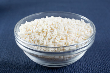 A closeup view of a glass bowl of sticky rice.