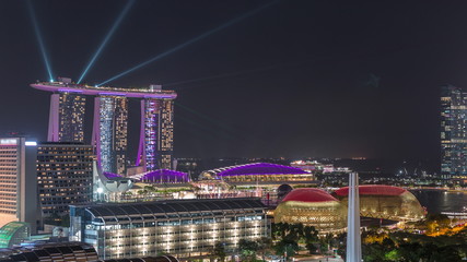 Fototapeta na wymiar Fifty-five storeys high Marina Bay Sands Hotel dominates the skyline at Marina Bay in Singapore aerial night timelapse.